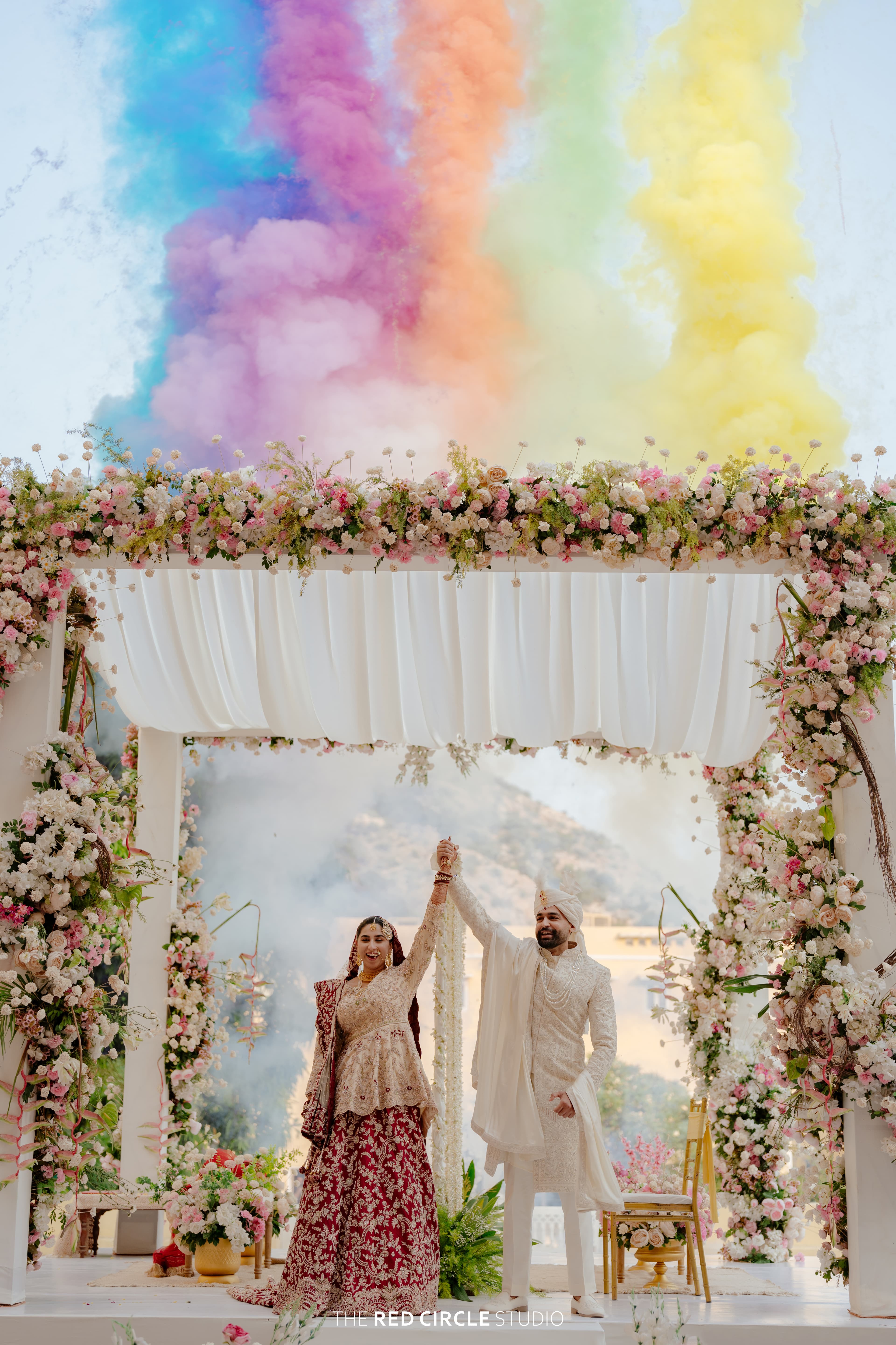 SNAP EMC — Couple at a floral wedding mandap with colourful smoke